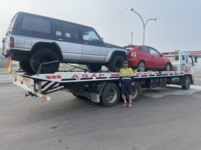 ASAP Towing driver beside the tilt tray truck