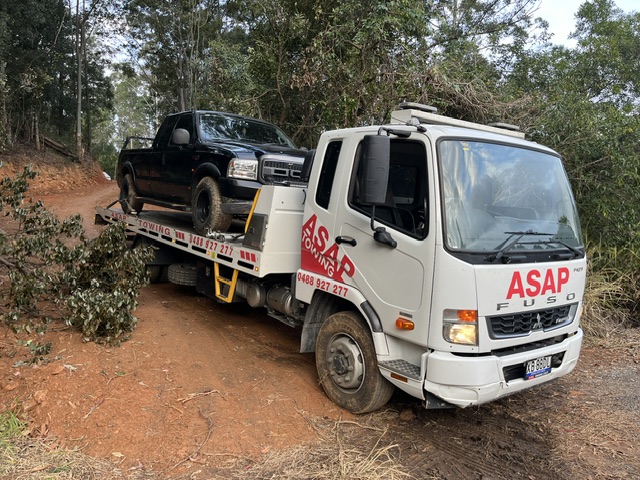 ASAP Towing tilt tray truck carrying a black ute